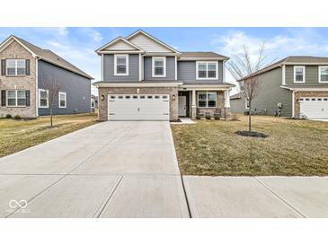 Charming two-story home with blue siding, brick accents, a two-car garage, and a well-manicured front lawn at 6713 Cardiff Dr, McCordsville, IN 46055
