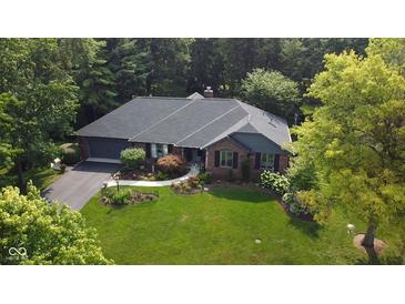 Charming brick home with a well-maintained lawn, landscaping, and an attached two-car garage at 7971 Clearwater Ct, Indianapolis, IN 46256