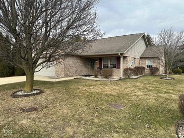 Charming brick home with an attached garage and a well-maintained lawn with mature trees at 8960 Stepping Stone Way, Avon, IN 46123