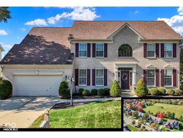 Charming two-story home featuring a brick facade, well-manicured lawn, and an attached two-car garage at 12396 Dellfield W Blvd, Carmel, IN 46033