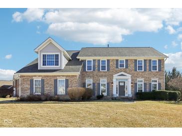 Charming brick home featuring gray shutters, a manicured lawn, and an inviting entrance with white columns at 14936 Newport Dr, Westfield, IN 46074