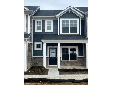 Charming two-story townhome with a covered porch, stone accents, and white framed windows at 19493 Grassy Branch Rd, Westfield, IN 46074