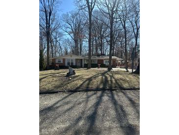 Charming single-story brick home with white shutters surrounded by mature trees at 28 Cambridge Ct, Anderson, IN 46012