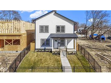 Charming two-story home with black fencing, lush lawn, and welcoming front porch at 35 N Keystone Ave, Indianapolis, IN 46201