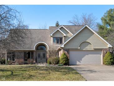 Charming two-story home featuring a brick facade, arched entryway, and attached two-car garage at 1110 Butternut Dr, Columbus, IN 47201