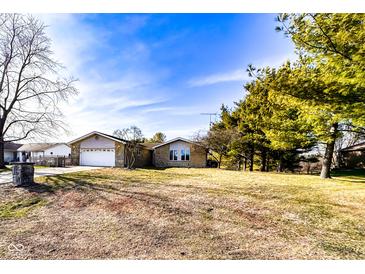 Charming single-story home with a well-manicured lawn and mature trees in a tranquil neighborhood setting at 12930 River Grove Dr, Columbus, IN 47203