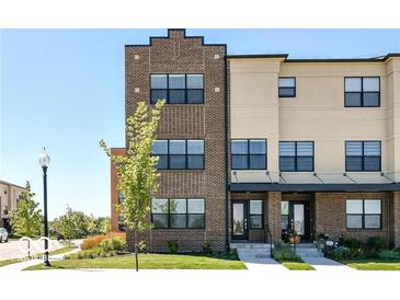 Modern brick and beige townhouse with black-trimmed windows under a clear blue sky at 12974 Pettigru Dr, Carmel, IN 46032