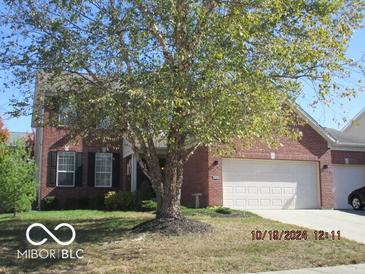 Charming brick home with a two-car garage and mature trees in the front yard at , Greenwood, IN 46143