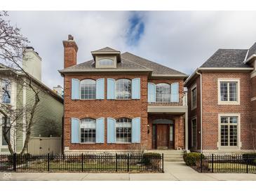 Charming two-story brick home featuring light blue shutters and a well-manicured front yard at 438 E Vermont St, Indianapolis, IN 46202