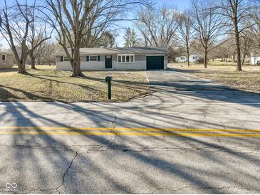 Charming single-story home featuring a gray brick exterior, attached garage, and a well-maintained front yard at 6603 Iona Rd, Indianapolis, IN 46203