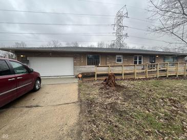 Single-story home featuring a ramp, attached garage, and stone facade at 721 Stover Ave, Indianapolis, IN 46227