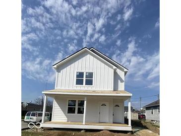 New construction two-story home with white vertical siding and a welcoming front porch at 929 N Beville Ave, Indianapolis, IN 46201