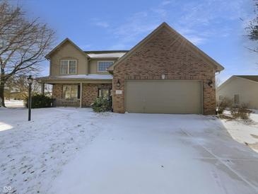Charming two-story home with brick facade, attached garage, and snow-covered front yard on a sunny day at 1059 Sugar Maple Dr, Greenwood, IN 46143