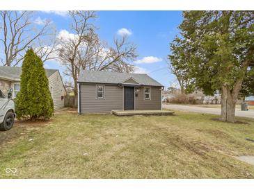Cozy one-story home with gray siding, a small front porch and a well-maintained lawn and trees at 1159 S Bradley Ave, Indianapolis, IN 46203