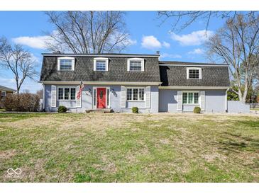 Charming home with a red front door, grey brick, shutters, and a well-maintained lawn at 1310 Bowman Dr, Greenfield, IN 46140