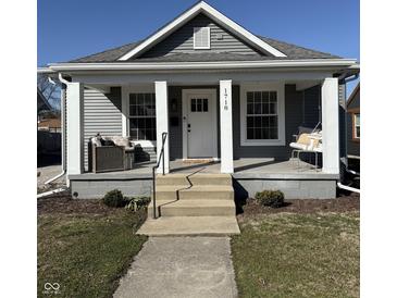 Charming home features a welcoming front porch with swing and seating, enhancing curb appeal at 1718 Gilmore St, Columbus, IN 47201