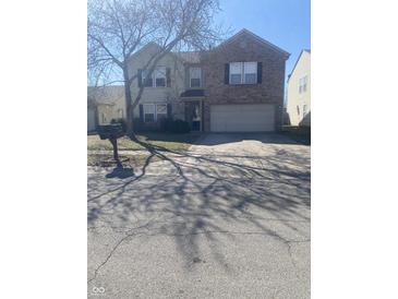 Two-story home featuring a blend of brick and siding, a two-car garage, and a spacious driveway at 1735 Sonesta Ln, Indianapolis, IN 46217