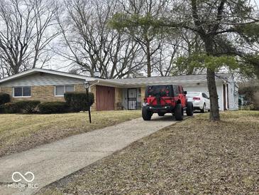 Charming single-story home with a long driveway and a combination brick and siding exterior at 4125 Dequincy St, Indianapolis, IN 46226
