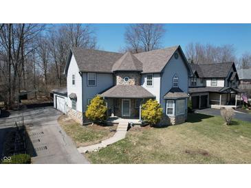 Charming two-story home with stone accents, well-maintained lawn and beautiful front yard landscaping at 5014 Melbourne Rd, Indianapolis, IN 46228