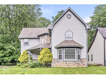 Charming home featuring stone accents, manicured landscaping, and a covered porch at 5014 Melbourne Rd, Indianapolis, IN 46228