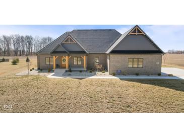 Charming brick home featuring a welcoming porch with timber supports and a beautifully landscaped yard at 5189 Abbeygate Blvd, Bargersville, IN 46106