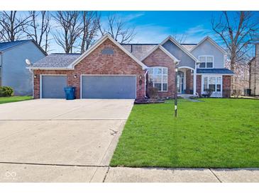 Charming two-story home featuring a brick facade, two-car garage, and well-maintained lawn at 5855 Dapple Trce, Indianapolis, IN 46228