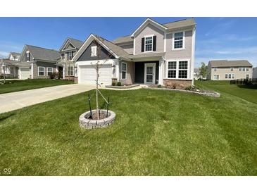 Charming two-story home featuring a well-maintained lawn, attached garage, and lovely curb appeal at 6830 Shooting Star Dr, Whitestown, IN 46075