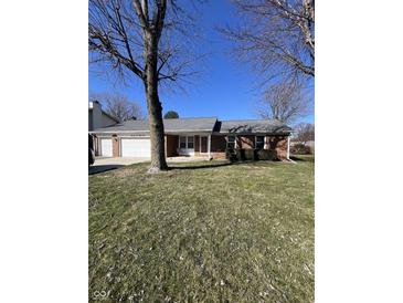 Charming single-story brick home with a two-car garage, covered porch, and well-maintained lawn at 7632 S Sherman Dr, Indianapolis, IN 46237