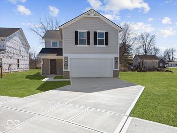Charming two-story home featuring a spacious driveway and an attached two-car garage at 1033 Fuller Ln, Shelbyville, IN 46176