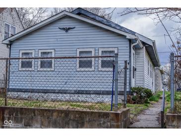 Quaint home featuring light blue siding, white trim, and a decorative eagle perched above the windows at 1937 N Lasalle St, Indianapolis, IN 46218