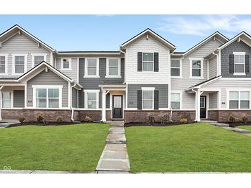 Charming townhomes showcase a landscaped front yard with a brick foundation and gray and white facade at 2171 Mildred Rd, Westfield, IN 46074