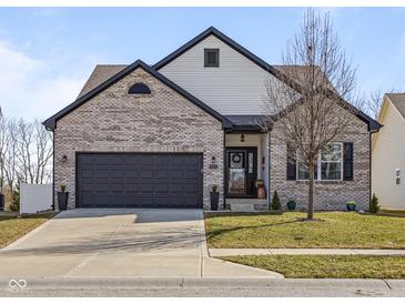 Charming two-story home featuring a grey brick facade, dark trim, a manicured lawn, and a two-car garage at 553 Farnham Dr, Westfield, IN 46074