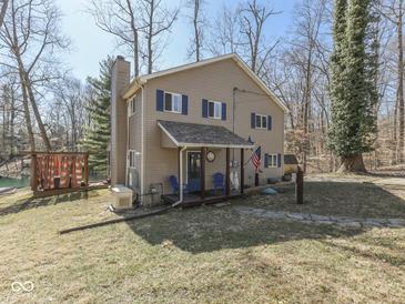 Inviting two-story home featuring blue shutters, covered porch, and lush natural surroundings at 8460 S Green Dr, Nineveh, IN 46164