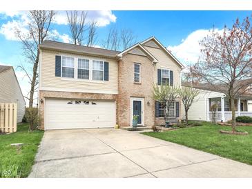 Charming two-story home with a well-manicured lawn, attached two-car garage, and inviting curb appeal at 9243 Crossing Dr, Fishers, IN 46037