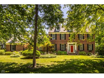 Charming brick home featuring a bright red front door and well-manicured landscaping at 1409 S Harmony Trl, Greenfield, IN 46140