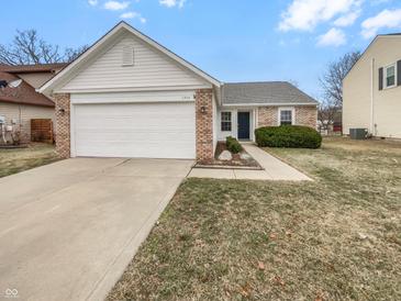 Charming single-story home featuring a brick and white vinyl facade, attached garage, and well-maintained landscaping at 1914 Kingen Dr, Greenfield, IN 46140