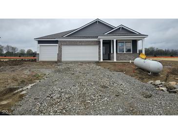 Charming single-story home featuring a two-car garage and a covered porch, set in a construction phase lot at 2254 Oakmont Dr, Plainfield, IN 46168