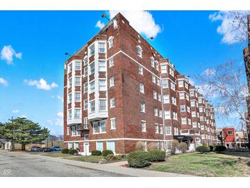 Brick apartment building exterior featuring classic architecture under a partly cloudy sky at 230 E 9Th St # Apt 405, Indianapolis, IN 46204