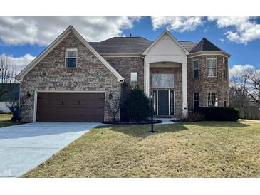 Two-story brick home with a two-car garage and a turret on a sunny day at 4309 Worchester Ct, Carmel, IN 46033