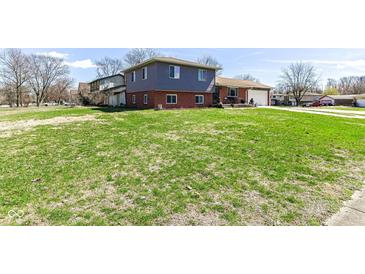 Spacious front yard showcasing a multi-level home with a blend of siding and brick exterior at 5414 Honey Comb Ln, Indianapolis, IN 46221