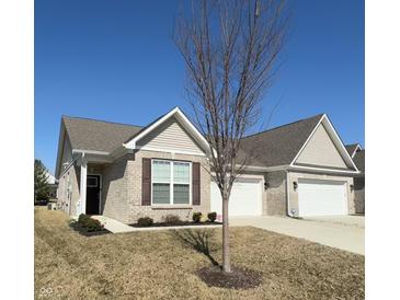 Charming single-story home with a brick facade, well-manicured lawn, and attached two-car garage on a sunny day at 6480 E Walton Dr, Camby, IN 46113