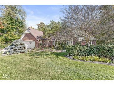 Charming brick home features a well-manicured lawn and mature trees creating a warm, inviting curb appeal at 8425 N Halyard N Way, Indianapolis, IN 46236