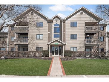 Inviting exterior view of a multi-story condo building with balconies, well-maintained landscaping, and clearly marked address at 8820 Yardley Ct # 101, Indianapolis, IN 46268