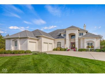 Stunning white brick home featuring a large three car garage and meticulously manicured lawn at 995 Westlake Hills Dr, Columbus, IN 47201