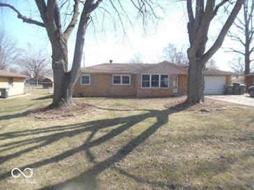 Charming single-story home with a brick facade and mature trees in the front yard at 32 S Elma St, Anderson, IN 46012