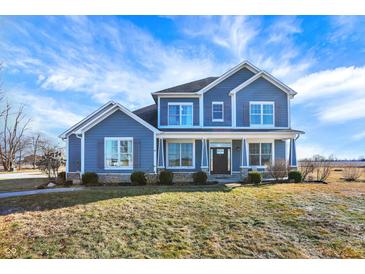 Inviting two-story home featuring blue siding, classic shutters, and a well-manicured lawn at 725 E County Rd 600 N, Pittsboro, IN 46167
