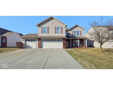 Charming two-story home with a three-car garage and well-maintained front yard on a sunny day at 11624 Eldridge Dr, Indianapolis, IN 46235