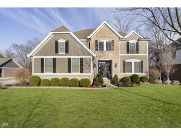 Charming two-story home with a manicured lawn, stone accents, and black shutters on a sunny day at 12433 Harvest Glen Blvd, Fishers, IN 46037