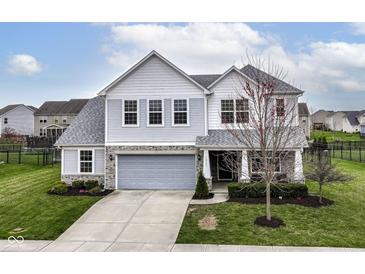 Beautiful two-story home featuring manicured lawn, stone accents, and attached two-car garage at 16753 Workington Way, Westfield, IN 46074
