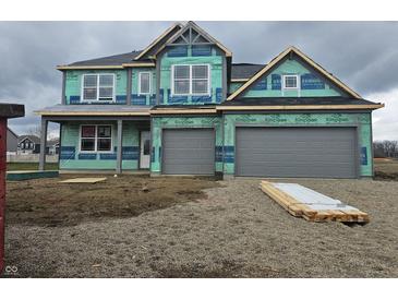 New construction home featuring a two-car garage and covered porch, set in a gravel lot with a cloudy sky at 2340 Pine Valley Dr, Plainfield, IN 46168